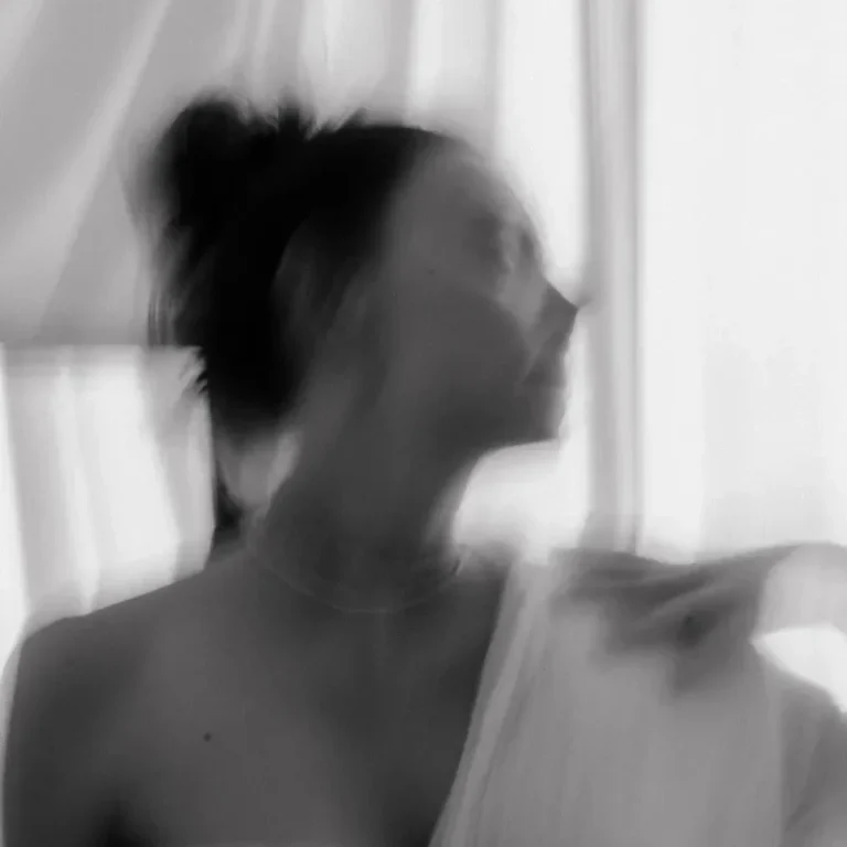 Natürliches Aktshooting in Münster Unscharfes Porträt einer Frau, die sich elegant zur Seite dreht.